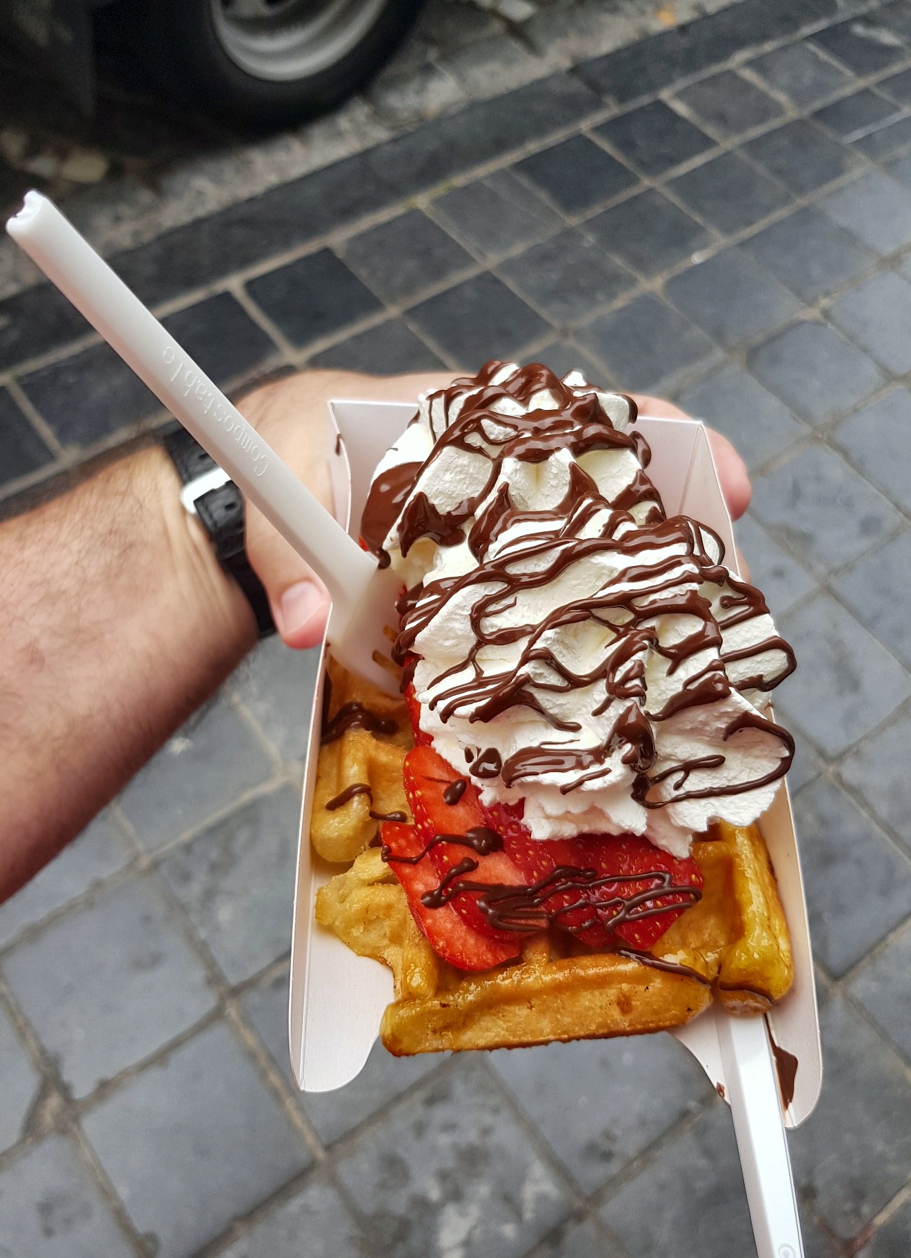 Belgian waffle in Bruges topped with strawberries, whipped cream and chocolate