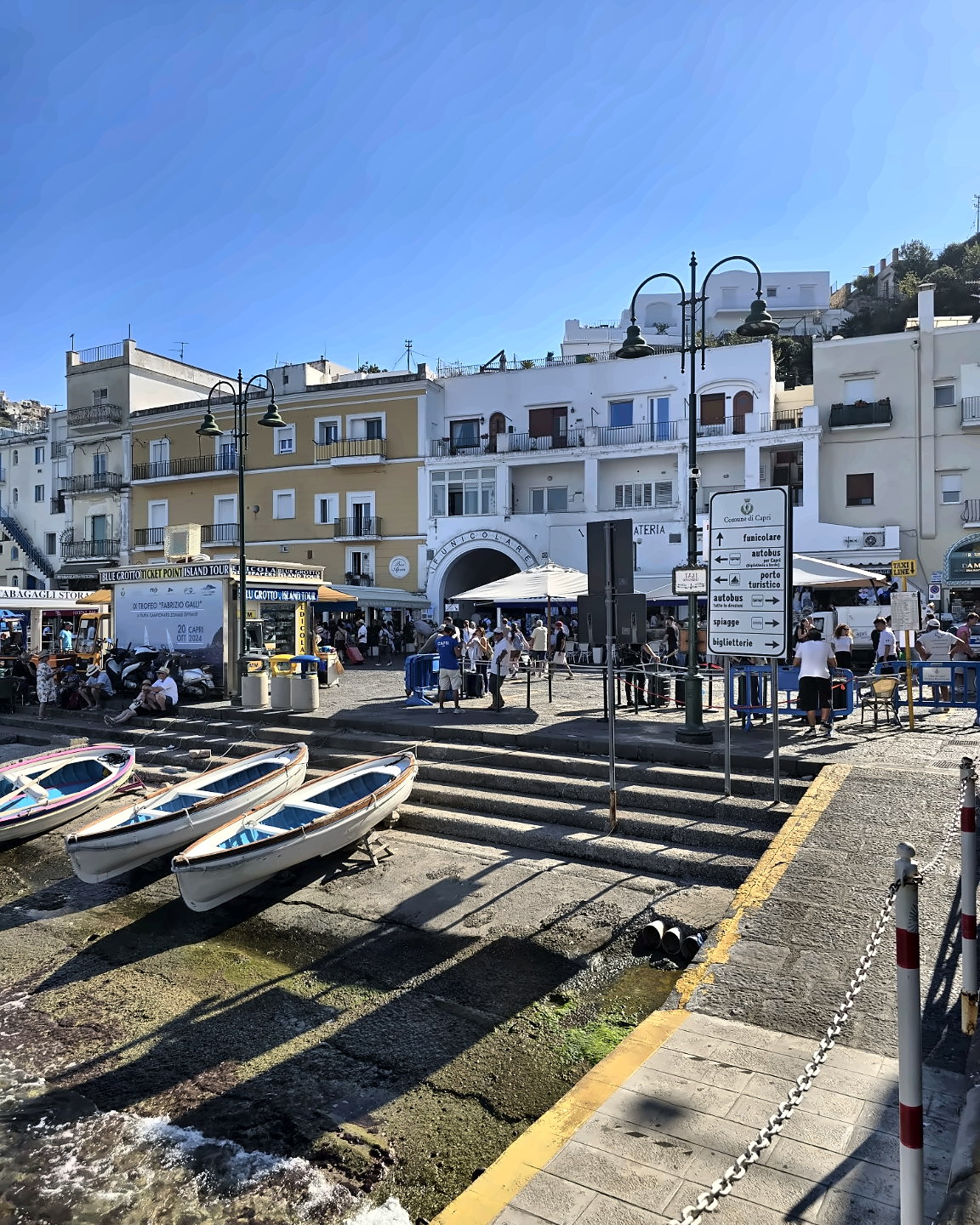 Marina Grande in Capri with the funicular entrance, boats and signs