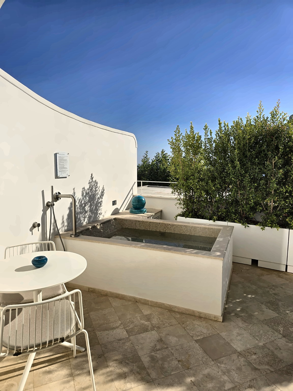 Private terrace of the Camerelle Suite with whirlpool, table and greenery