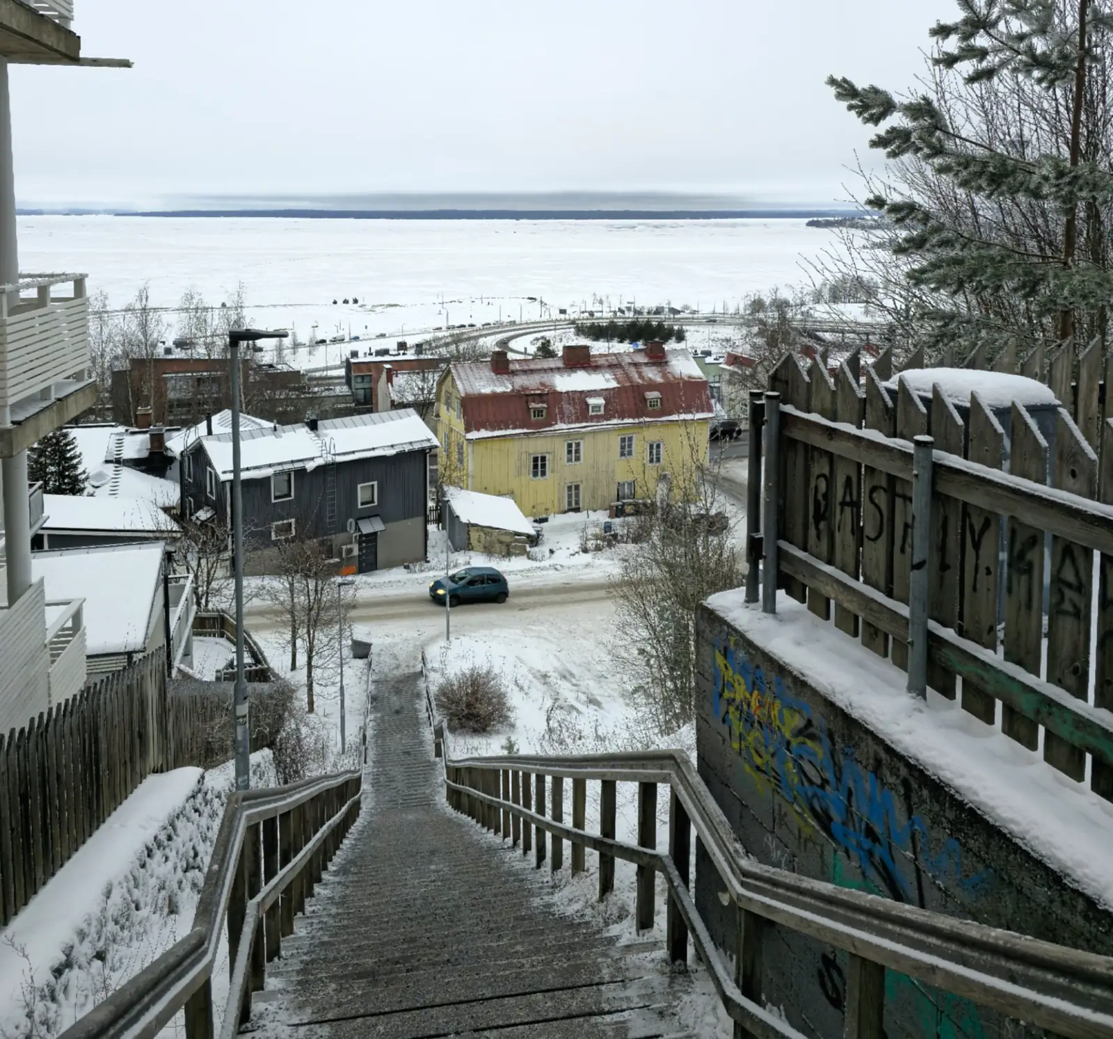 Snowy stairs descending through Pispala towards frozen Lake Näsijärvi