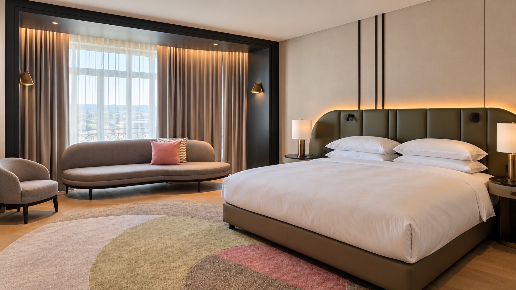 Hotel room in Luxembourg with a curved sofa beside the window overlooking the railway station
