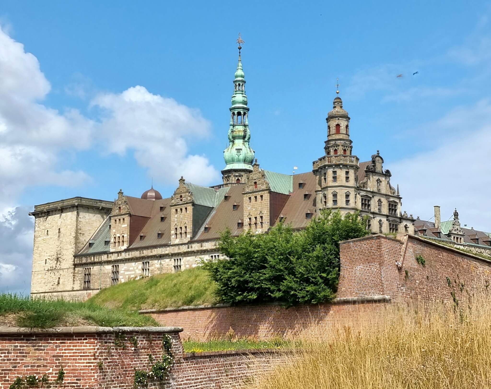 Bočni pogled na Kronborg iznad ciglenih utvrda i travnatih bedema.