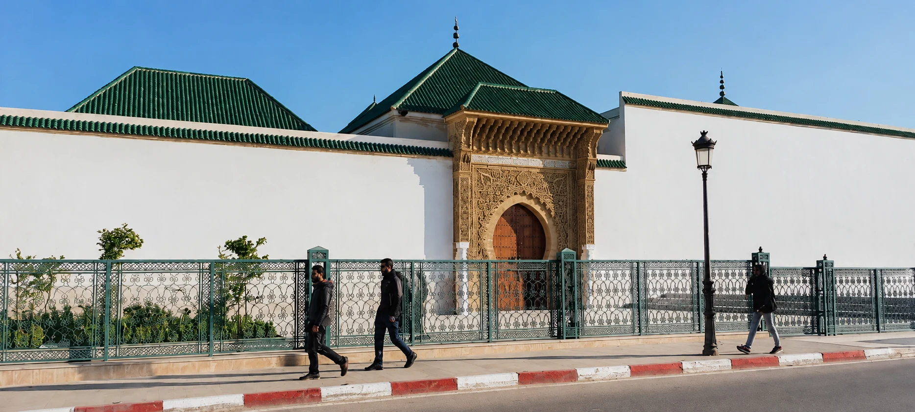 Mausoleum of Moulay Ismail with green-tiled roofs and an ornate gate in Meknes.