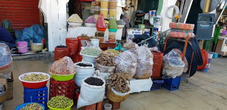 Spices, olives, dried goods and coiled hoses displayed outside a shop in Moulay Idriss medina.