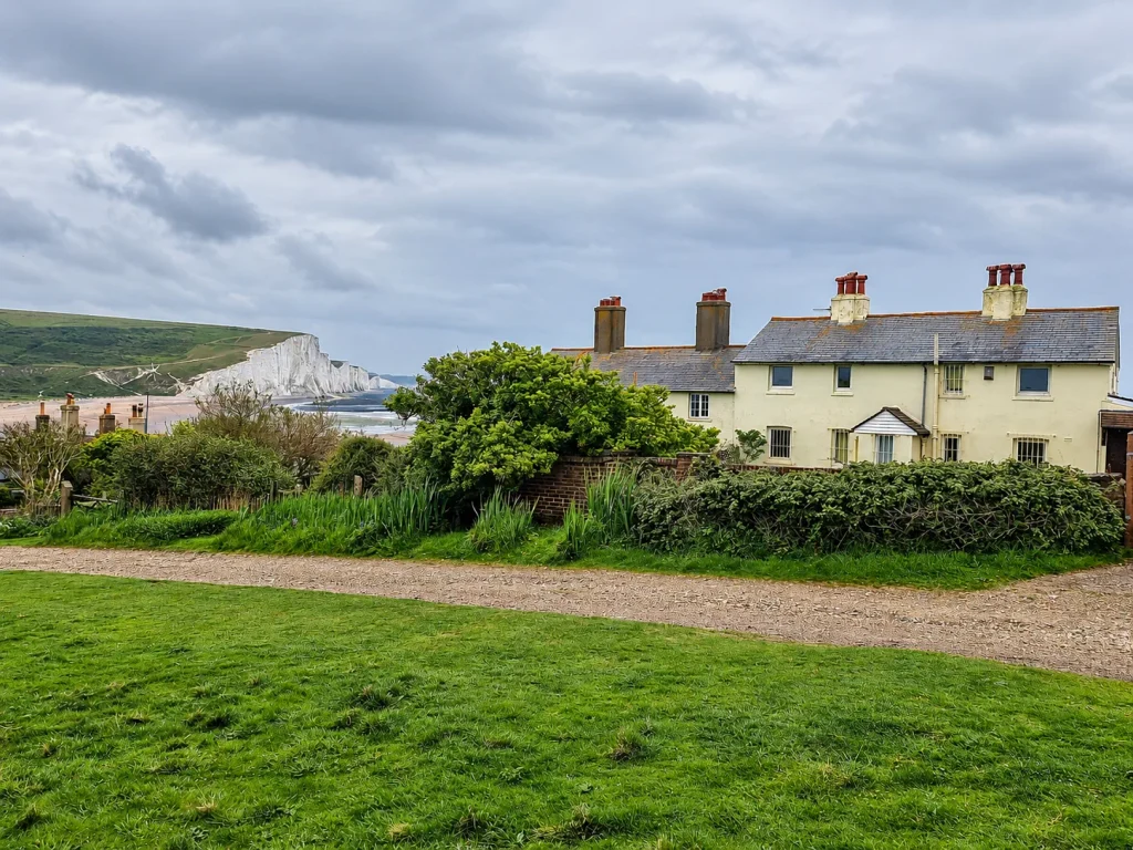 Coastguard Cottages with the white Seven Sisters cliffs beneath an overcast sky